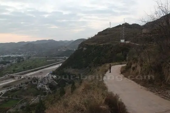 standing on a mound by the mountain road, waiting for the rising sun.