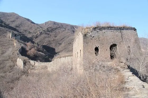 taking a picture of the tower sitting on an overgrown and crumbling wall winding up on the hillside
